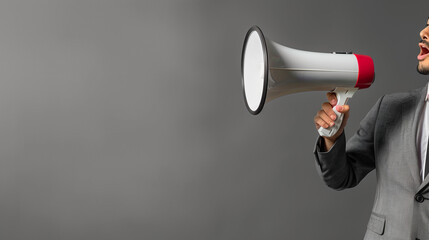 Recruitment or job announcement concept with Businessman hand holding megaphone wearing grey suit isolated on grey background copy space for text, 