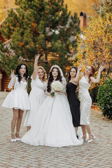 Fototapeta premium A group of women are posing for a picture, with one of them wearing a white wedding dress