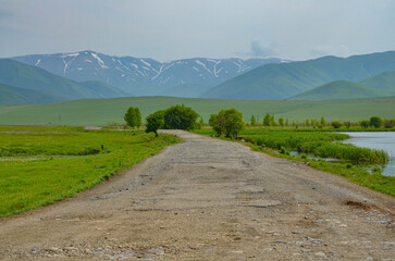 Fototapeta premium country road in alpine grasslands near Saratovka village (Lori province, Armenia) 