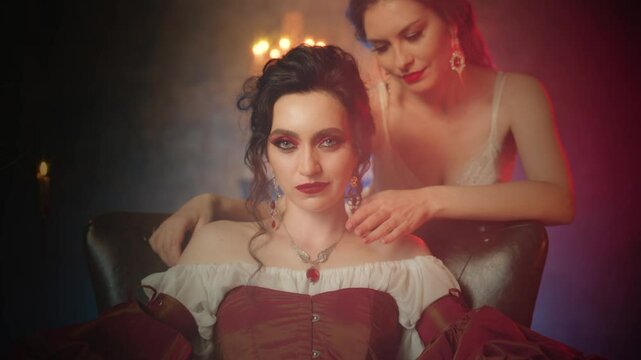Two women vampires. beauty woman Fantasy lady evil face vampire queen girl biting victim neck drinking blood with sharp fangs teeth red lips makeup close-up. dark night room gothic old style art 4k