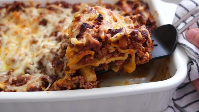 Traditional meat lasagna in a white baking dish.