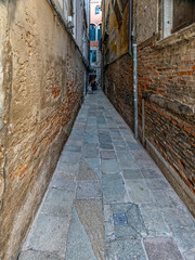 Passing through a narrow Venetian alley. Travel to Venice, Italy.