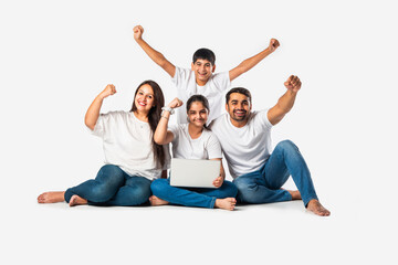 Indian asian young family with parents and kids using computer while sitting isolated on white