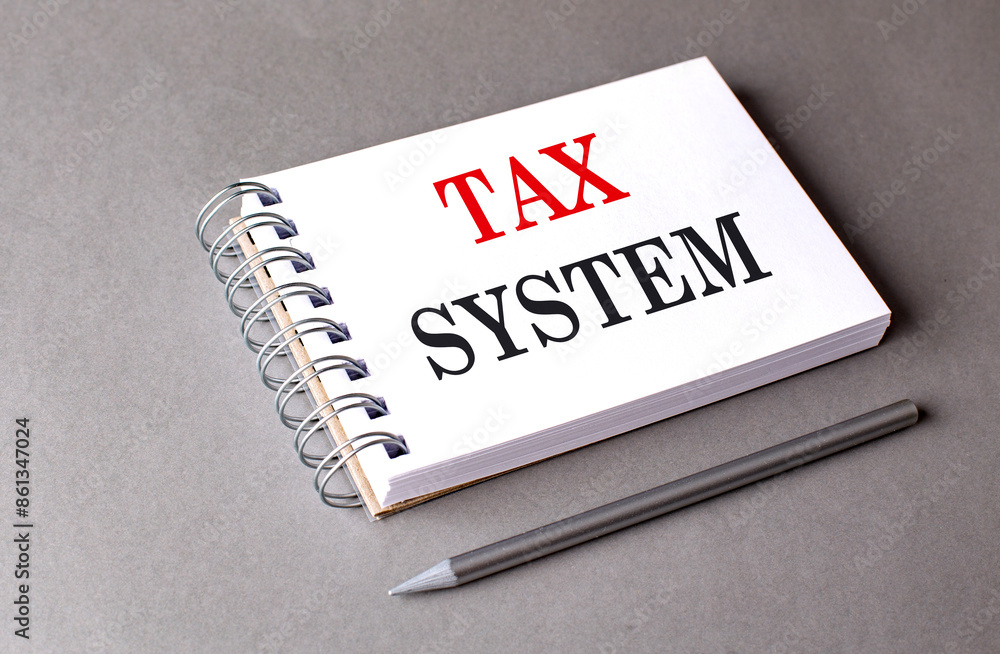 Poster tax system text on notebook on grey background
