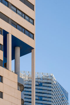 A closeup view of a high-rise building featuring a unique and intricate architectural style, highlighting its complex design and structural elements against a clear sky in Barcelona Spain