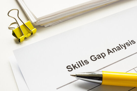 Stack of papers with skills gap analysis.