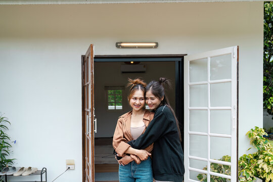 Happy Lesbian Couple Embracing in Front of New Home - LGBT Moving Day Concept