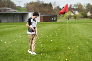 Young golfer playing golf and looking involved