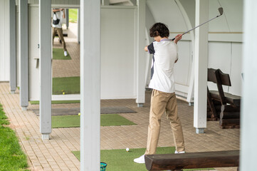 Young golfer exercising in playing golf and looking involved