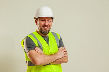 The guy shows different gestures with his hands  A guy in a white construction helmet, a gray T-shirt shows different gestures with his hands