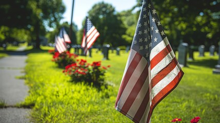A sunny day in a cemetery adorned with American flags, with gravestones and flowers, representing respect and tribute to those who served.