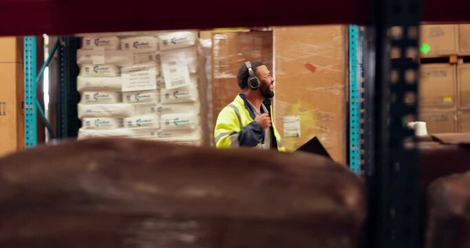 Shipping, fist bump and man dance in warehouse for inspection, supply chain and delivery. Factory, distribution and happy person with music in headphones for logistics, manufacturing and production