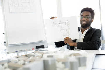 Smiling and successful dark-skinned businessman in his office