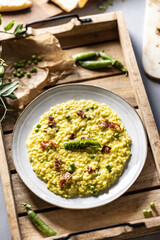 Italian saffron risotto with peas and bacon creatively served on a plate