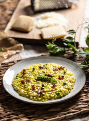 Italian saffron risotto with peas and bacon creatively served on a plate