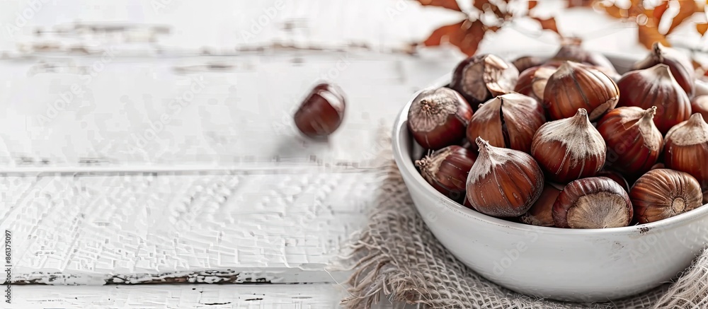 Poster Selective focus on a bowl of freshly boiled chestnuts on a white wooden table with room for text or other elements in the image. copy space available