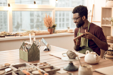 African american sculptor conducting a n online tutorial and looking contented