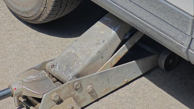 Mechanic lifts the car using a jack