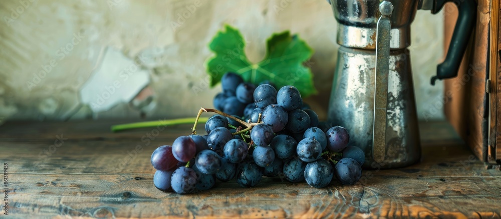 Poster black grapes on a wooden table with space for text, next to a coffee percolator. copy space availabl