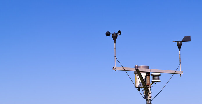 Close-up of an anemometer for measuring wind speed, a small weather station. Anemometer on a blue sky background, copy space
