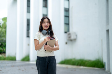 A woman wearing headphones and holding a book