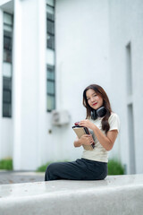 A woman wearing headphones and holding a book