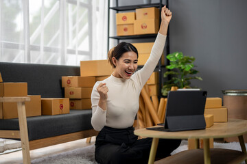 A woman is sitting on a couch in a room with boxes and a laptop