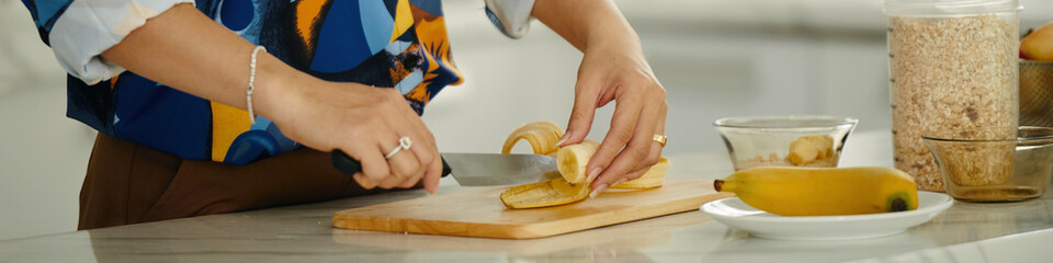 Header with young woman cutting fruits for breakfast