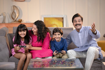 Sibling Playing Video Games At Home With Parents At Home