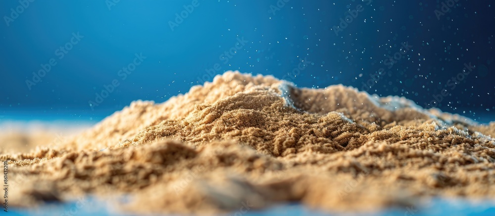 Poster close-up of a pile of sand with a blue background, featuring ample copy space image.
