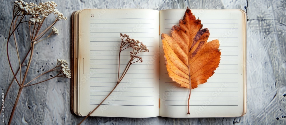 Aufkleber An autumnal leaf and a dried plant arranged on an open notebook with copy space image.