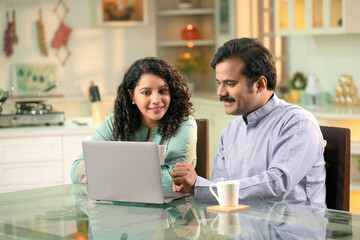 Loving Young Couple Enjoying Coffee And Surfing The Internet On Their Laptop