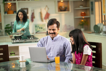 Obraz premium Father And Daughter Surfing On Internet On Laptop