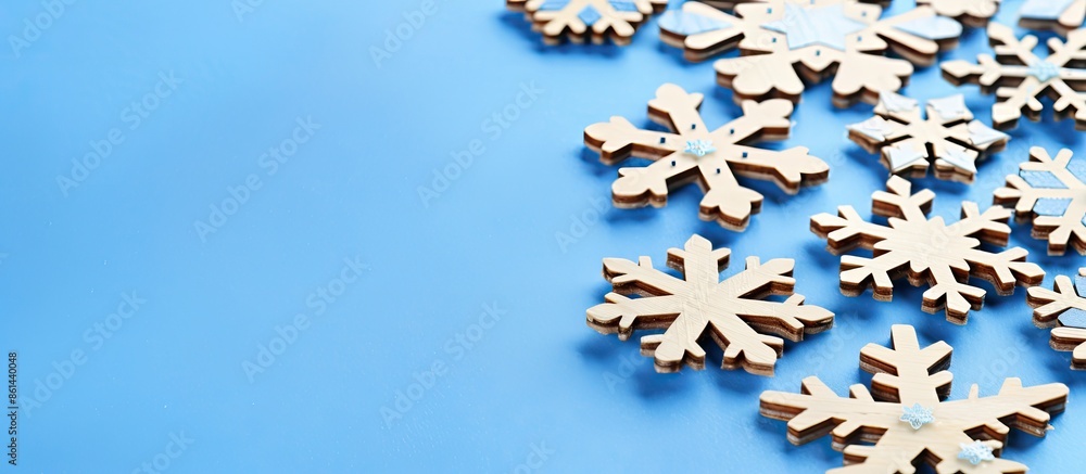 Poster close-up view of decorative wooden christmas snowflakes on a blue background, creating a festive new