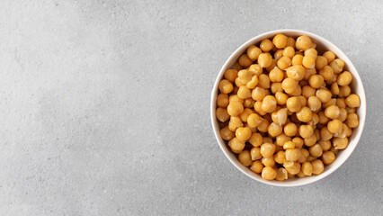 Canned chickpeas in small bowl on light grey background. Copy space