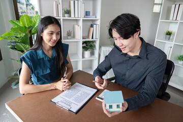 Obraz premium Real Estate Agent Buy Sell Contract Signing with Happy Clients and Agent in Modern Office Environment