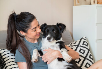 Happy Woman Hugging her Adopted Black Dog at Home