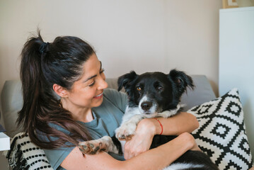 Happy Woman Hugging her Adopted Black Dog at Home