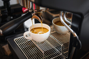 Professional espresso machine while preparing  espressos coffee cup in a coffee shop. Close-up of espresso pouring from the coffee machine