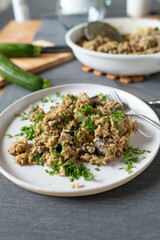 Healthy vegetarian rice dish with brown rice, eggplant, zucchini and scrambled eggs on a plate