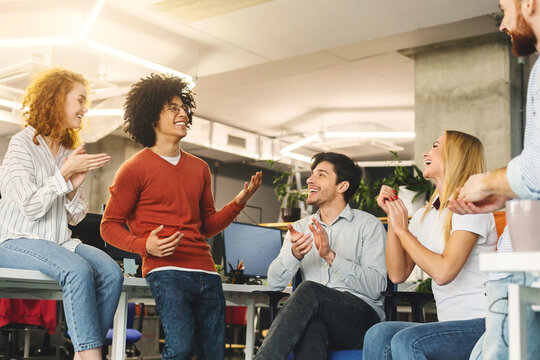 Creative team enjoying communication in modern office, discussing ideas for startup, empty space
