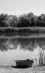 Landscape with a boat on the river bank in black and white