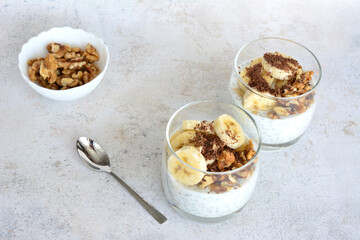 chia pudding with bananas and oatmeal are on a table in drinking glasses
