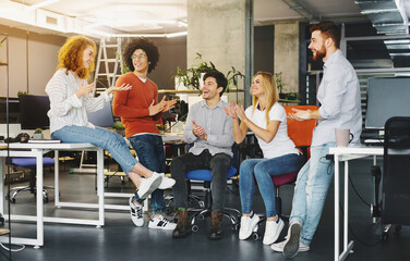 Welcome to team. Cheerful coworkers welcoming new colleague in modern coworking space