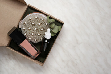 Gift box with cosmetic products on pastel marble table. Body treatment, skincare. Concept of sale, gifts on Valentines day or mother day. Top view, flat lay. Space for text. 