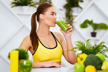 Healthy Lifestyle. Slim Girl Drinking Smoothie After Training, Sitting In Kitchen