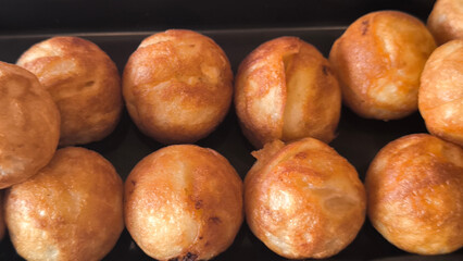 Takoyaki snacks on a black tray, Japanese style food