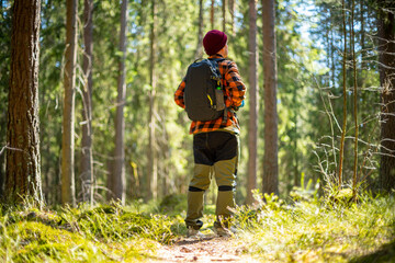 male hiker standing in a middle of a forest and enjoying the scenery