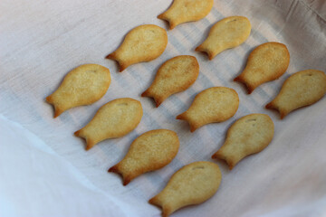 Fresh fish-shaped crackers with cheese on a white towel angle view