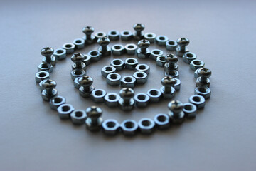 Rings made of steel color nuts and bolts screwed into them at regular intervals angle view stock photo for mechanical backgrounds
